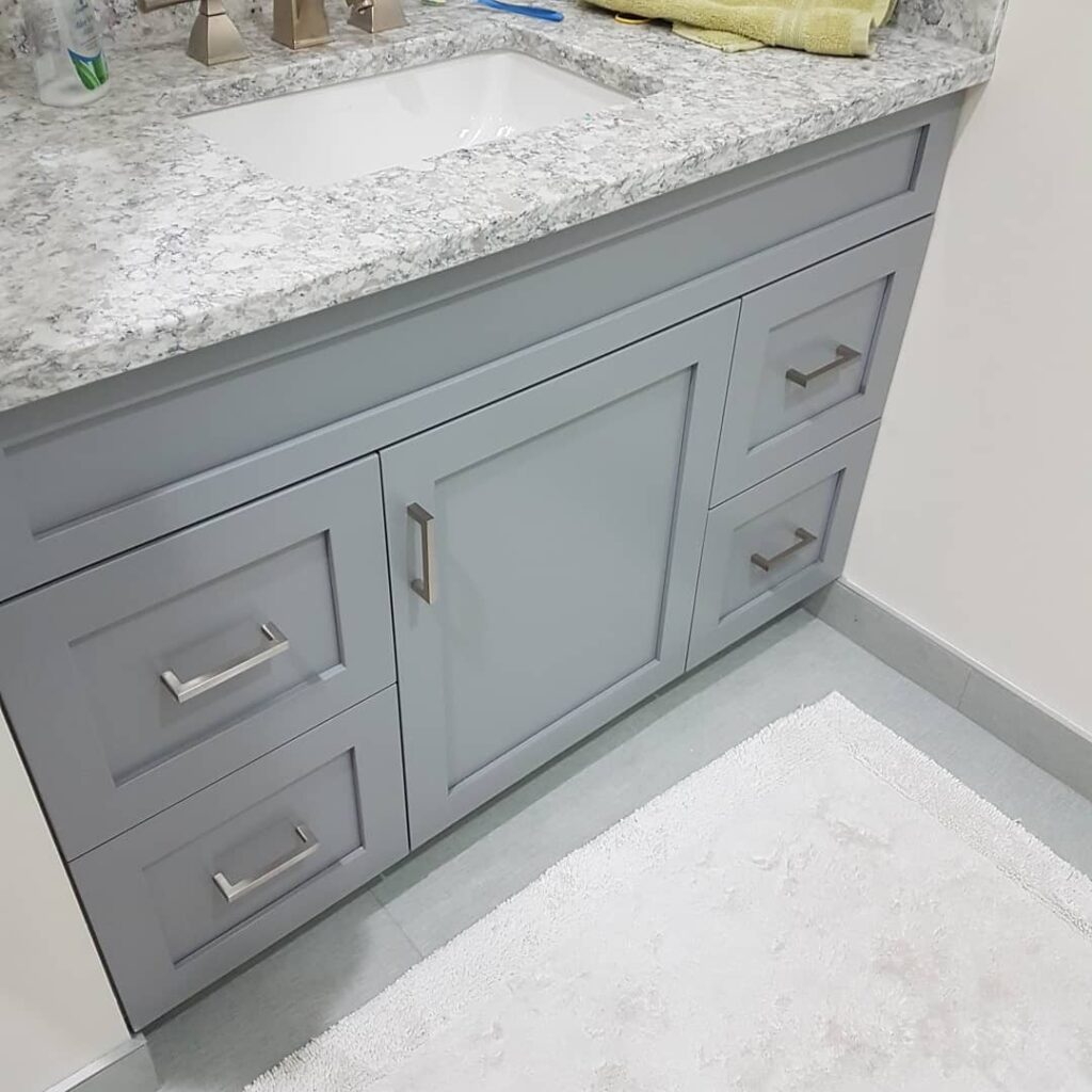 Grey shaker bathroom vanity with granite countertop and brushed-nickel pulls