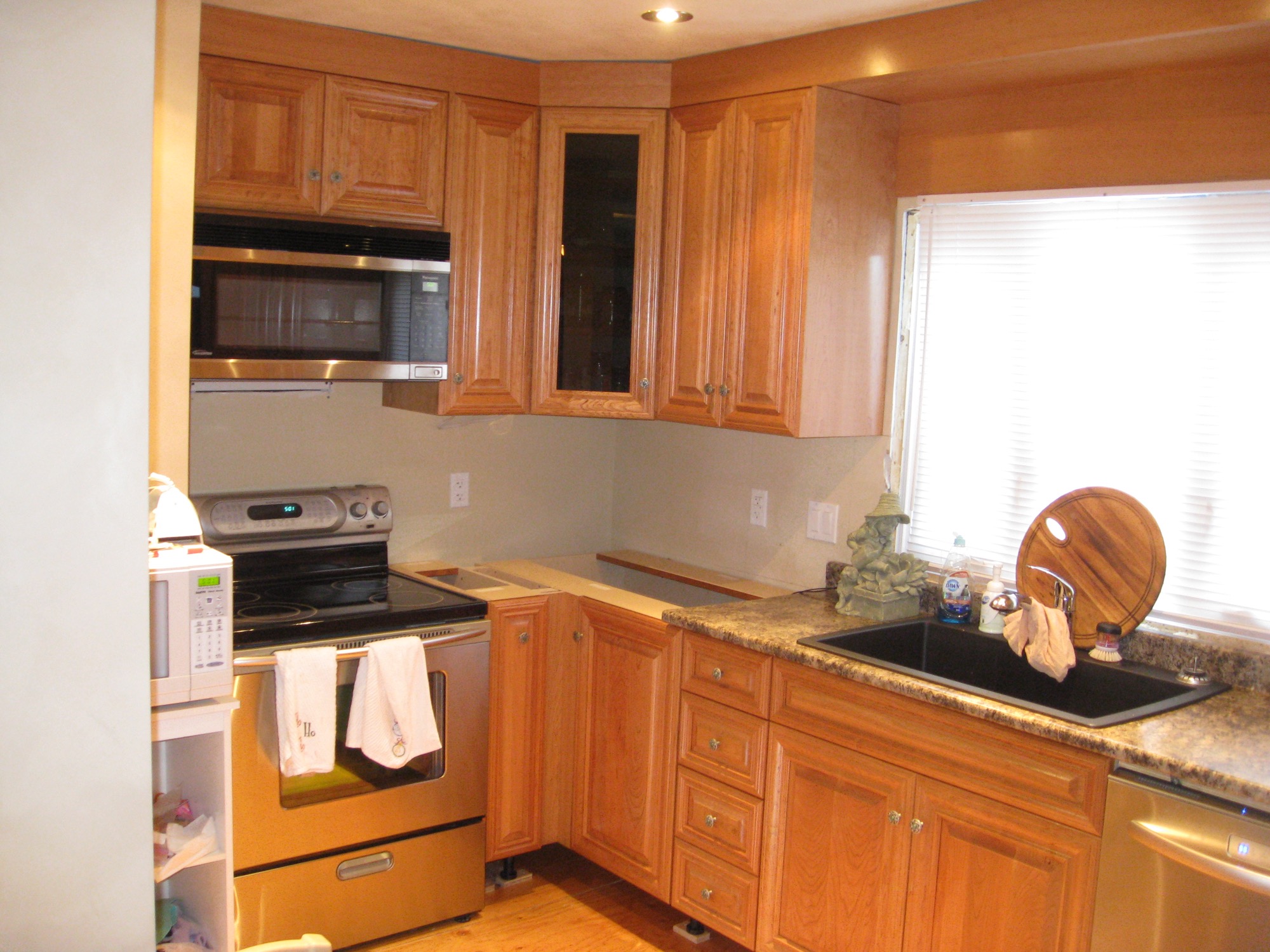 Cherry kitchen cabinets with a glass-front upper and granite countertops