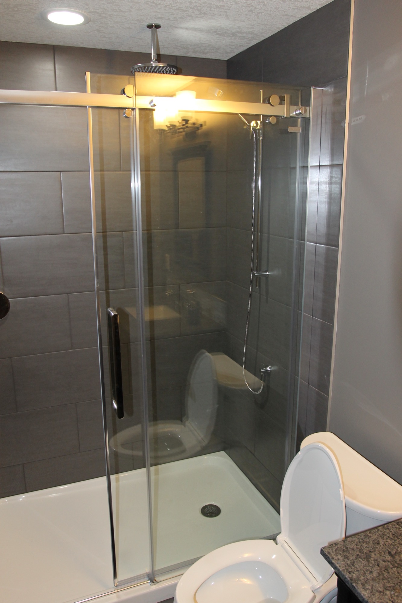 Glass shower enclosure with rain shower head